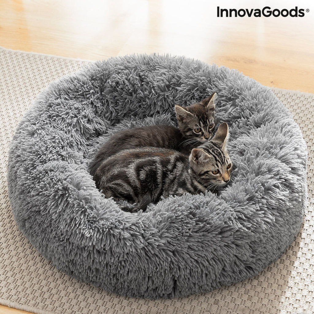Cats curled up together inside a grey round pet bed.